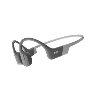 Shokz OpenRun Bluetooth fülhallgató a fül előtt, szürke színben